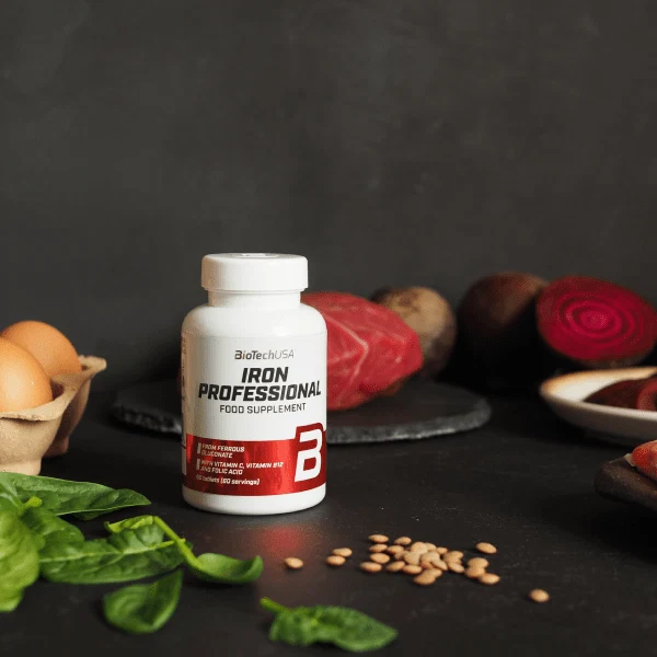 Опаковка на BioTech USA Iron Professional, поставена до блистер с таблетки, показваща съдържанието и брандирането.