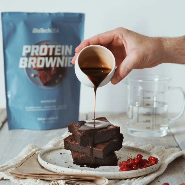 Приготвено протеиново брауни, нарязано на парчета, върху дъска за рязане