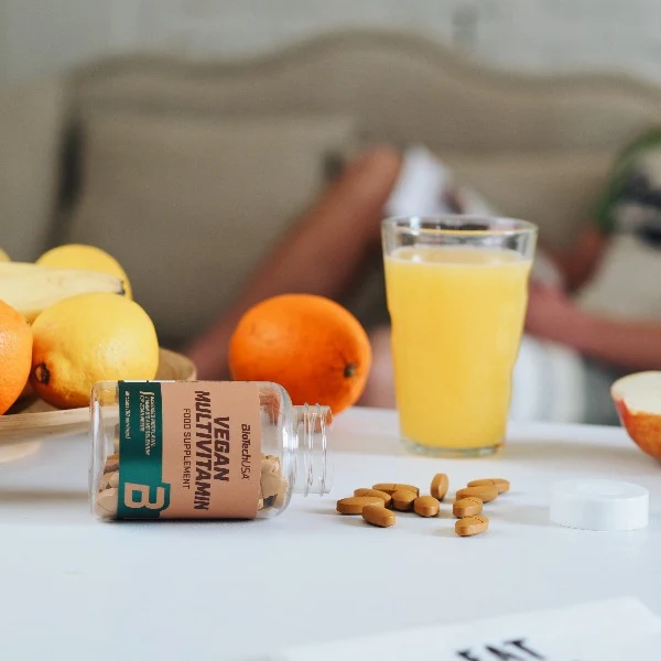 Таблетки BioTech USA Vegan Multivitamin, изсипани върху плоска повърхност