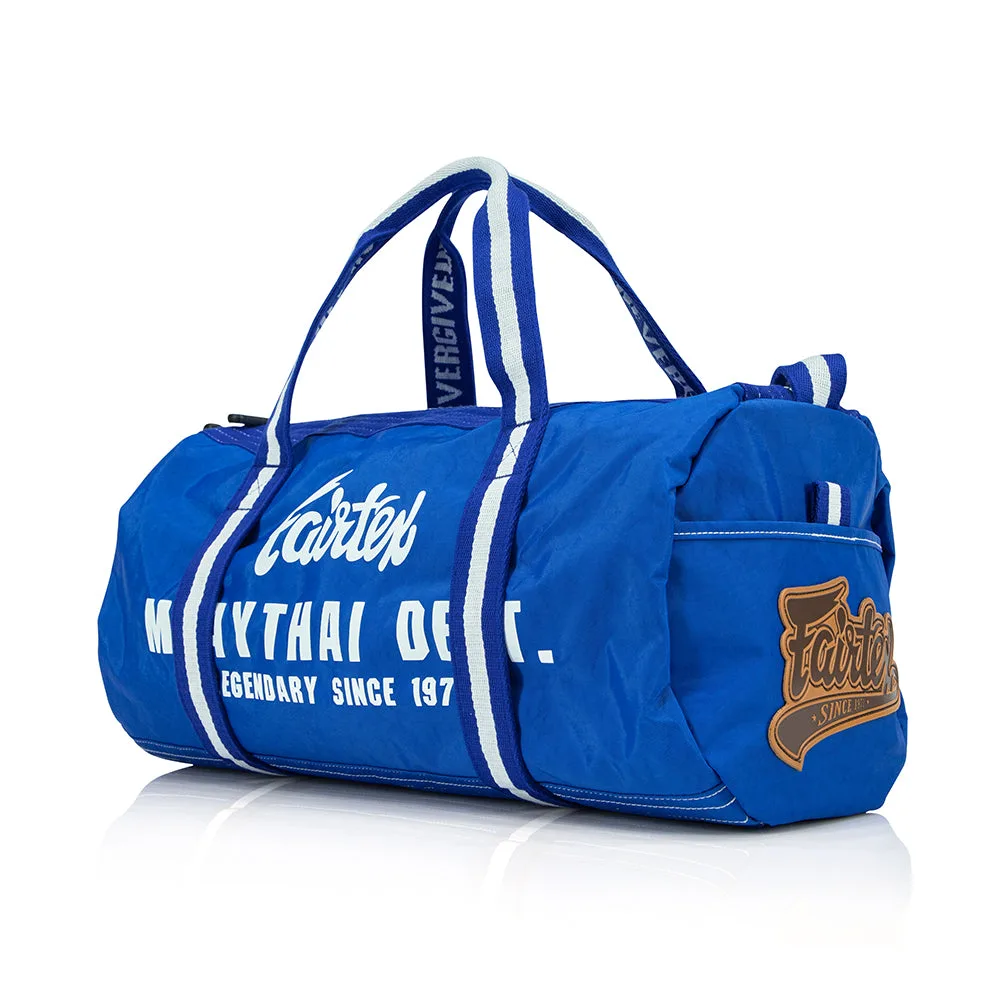 Син спортен сак Fairtex Barrel Bag, поставен на светъл фон, показващ предната си част и страничната дръжка.