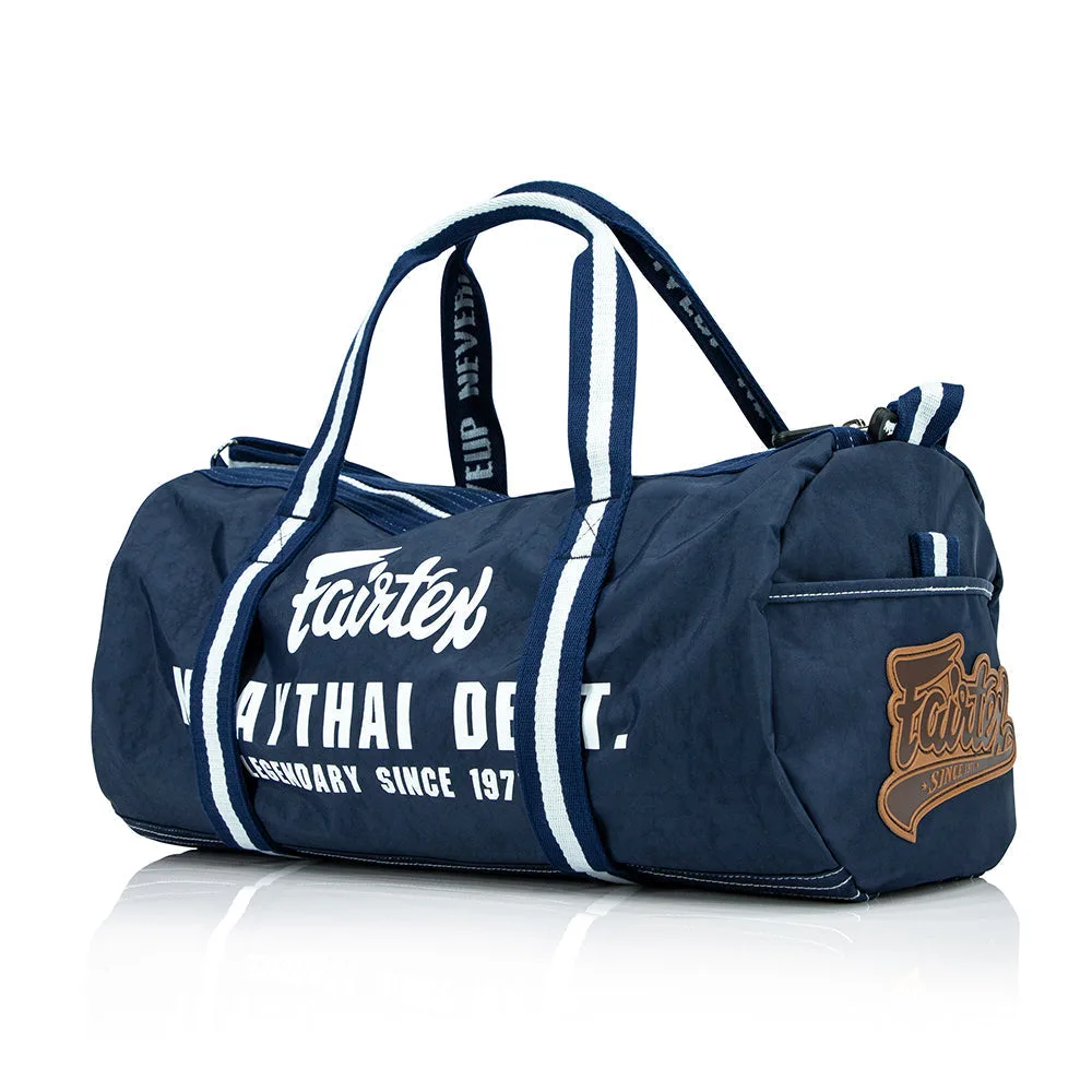 Тъмносин сак Fairtex Barrel Bag, тип бъчвичка, с цип и логото на Fairtex, подходящ за спорт и ежедневие.