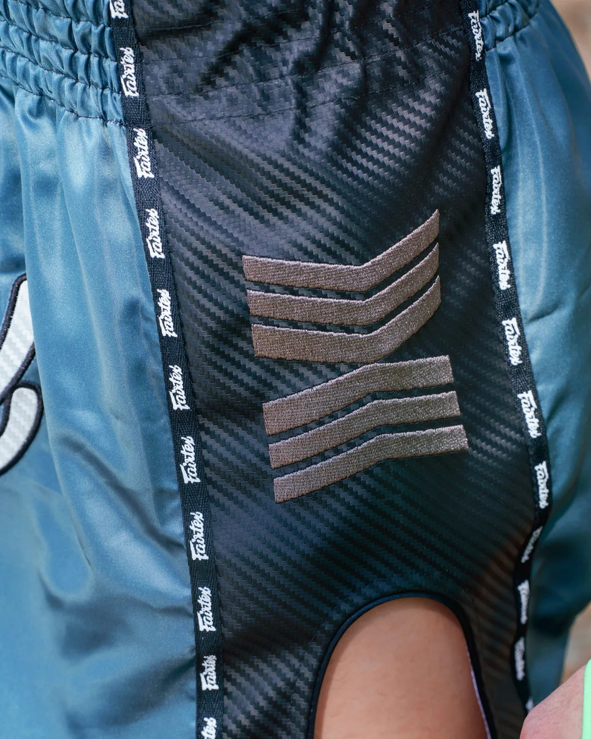 Шорти за муай тай Fairtex Arokaya Special в Teal Phantom, показани отстрани, подчертавайки свободата на движение, която осигуряват страничните цепки.