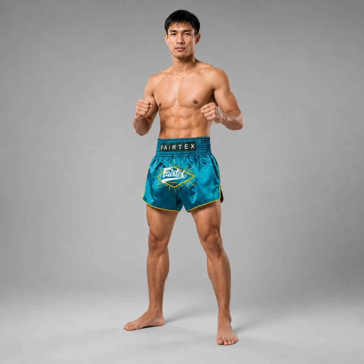 Детайлен изглед на жълтите кантове и логото на Fairtex върху зелените шорти