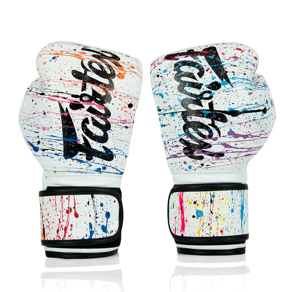 Бели боксови ръкавици Fairtex Painter BGV14PT с артистични пръски боя, показани отпред.