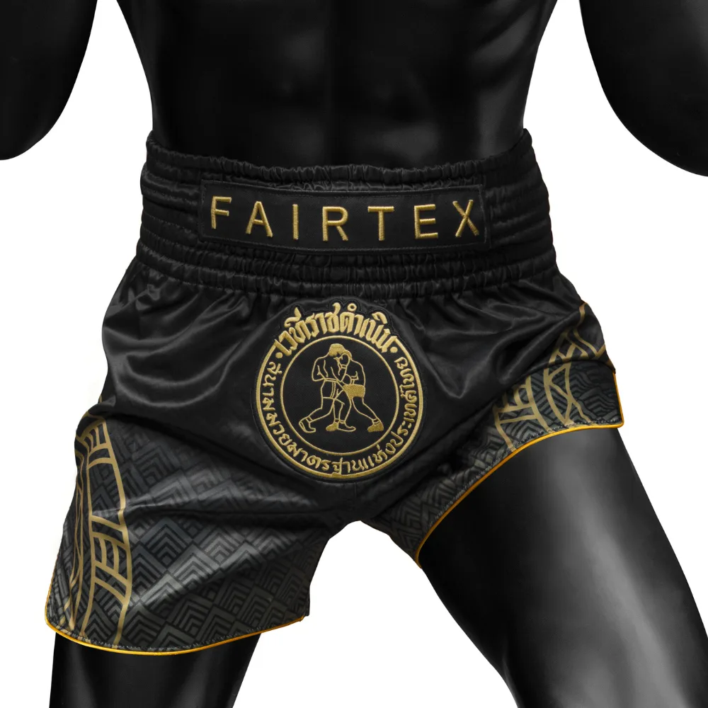 Fairtex x Rajadamnern Muay Thai Шорти - Черно/Златно с детайлни геометрични шарки на фона на ринг или тренировъчна зала