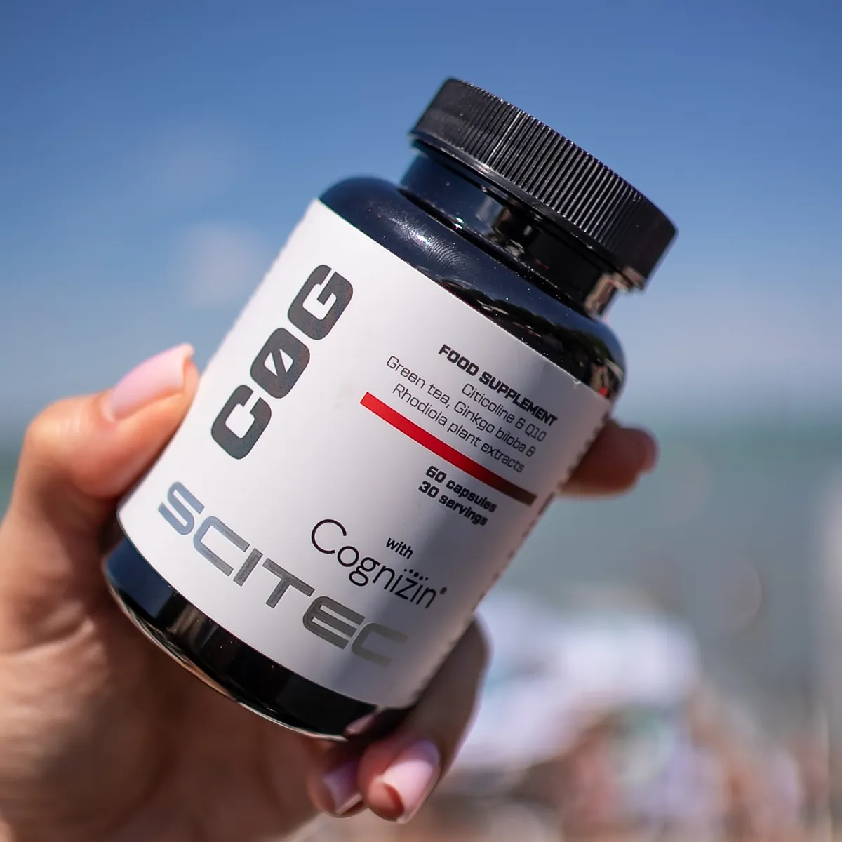 Близка снимка на капсулите Scitec Nutrition C0G, показваща цвета и формата им, до част от опаковката.