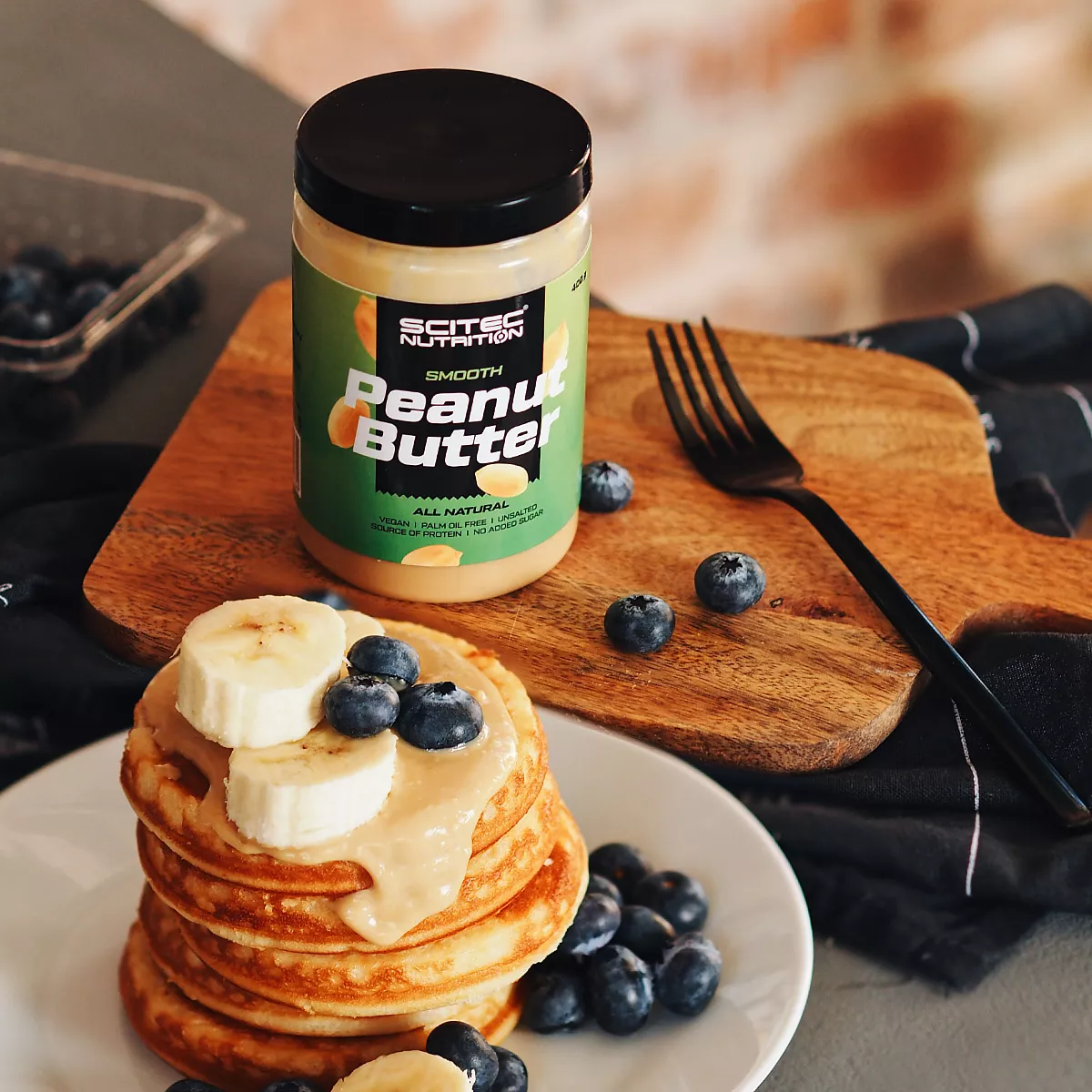 Отблизо на фъстъчено масло Scitec Nutrition, показващо хрупкава текстура с парченца фъстъци
