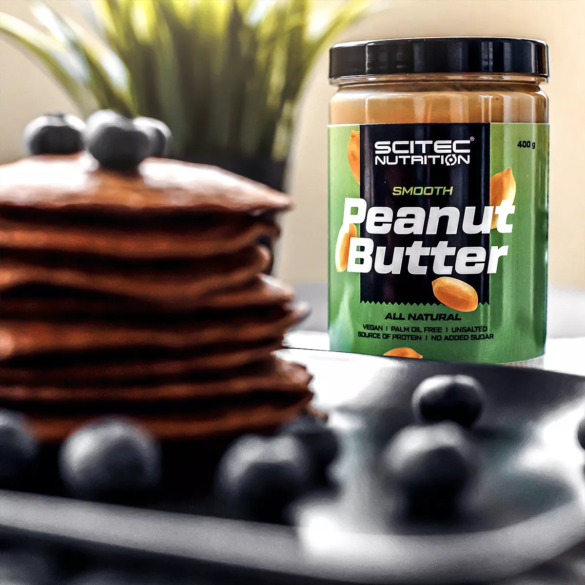 Буркан Scitec Nutrition Peanut Butter до купичка с фъстъци, подчертавайки естествения състав