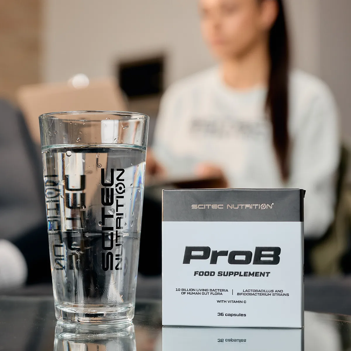 Scitec Nutrition ProB, изобразен до чаша вода, символизиращ начина на прием.