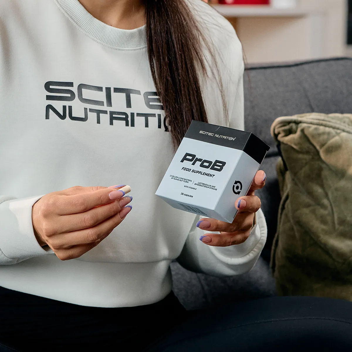 Капсула Scitec Nutrition ProB, извадена от опаковката, показваща нейната форма и размер.