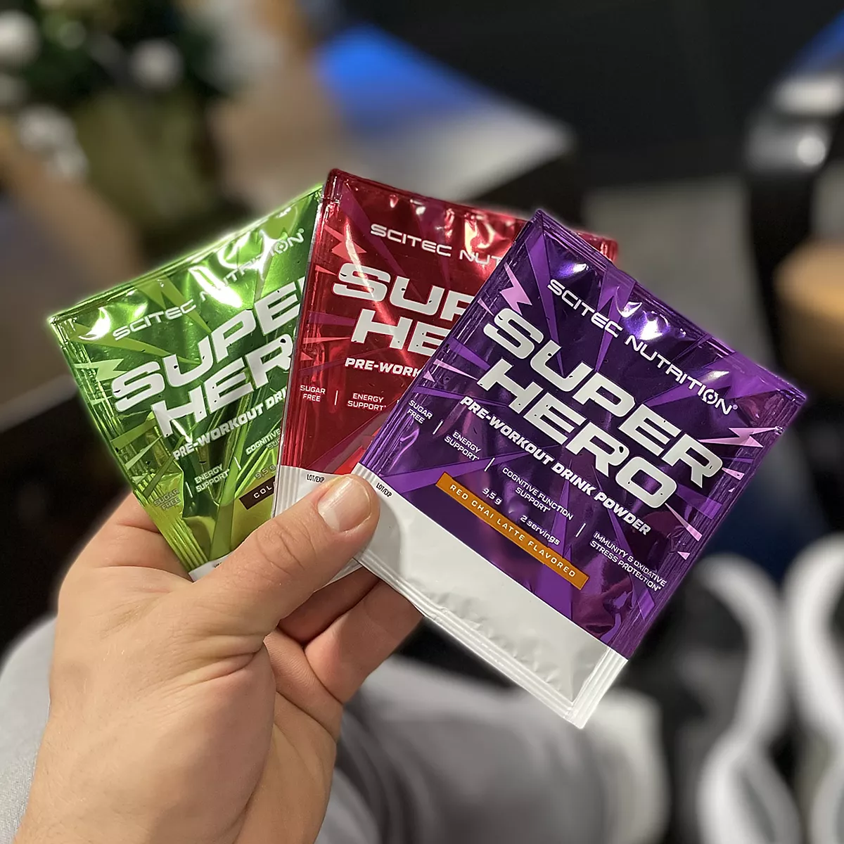 Опаковка на Scitec Nutrition Superhero с вкус кола-лайм, изобразяваща логото на Scitec и ключови характеристики на продукта.
