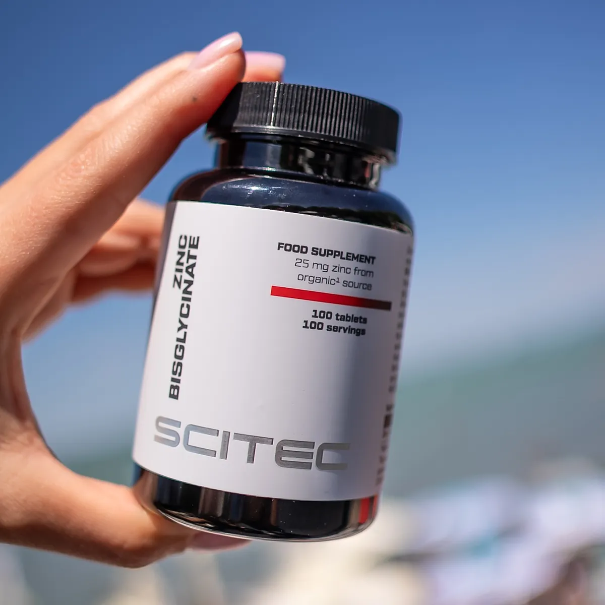 Scitec Nutrition Zinc Bisglycinate в ръка, показваща размера на таблетката