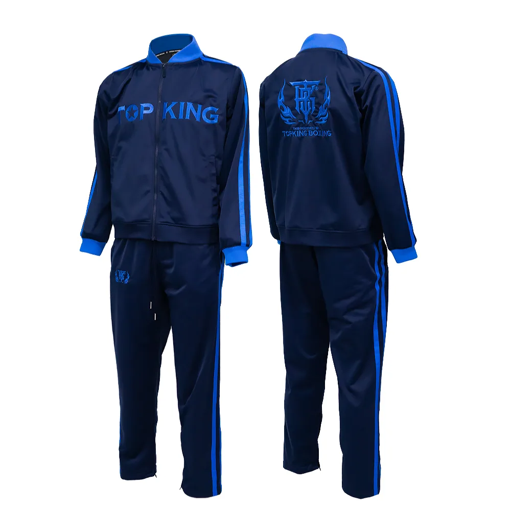 Мъж, облечен в син анцуг Top King Tracksuit Blue 011, позира в спортна обстановка.