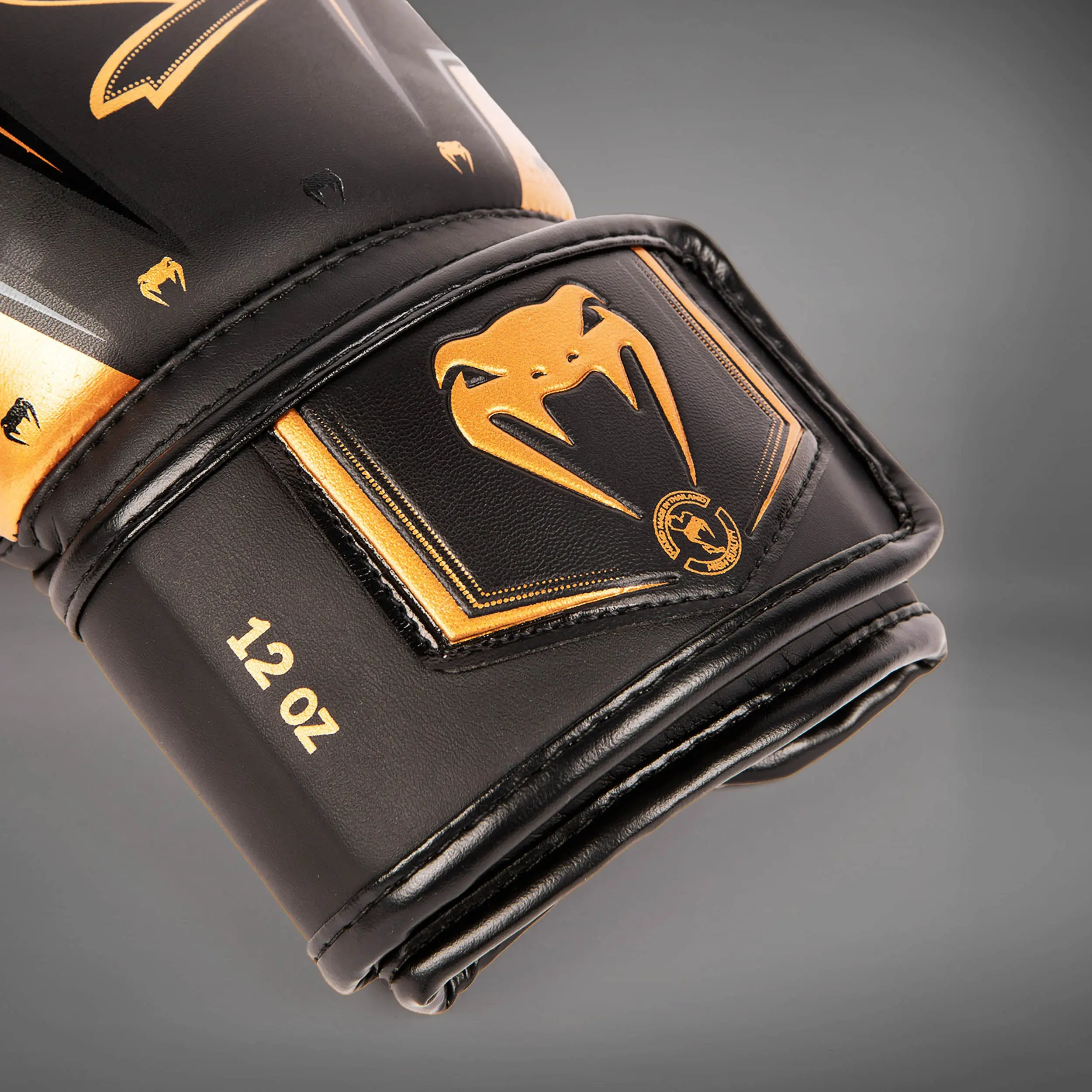 Venum Elite Evo Boxing Gloves - Black/Bronze, детайл от маншета с лого Venum
