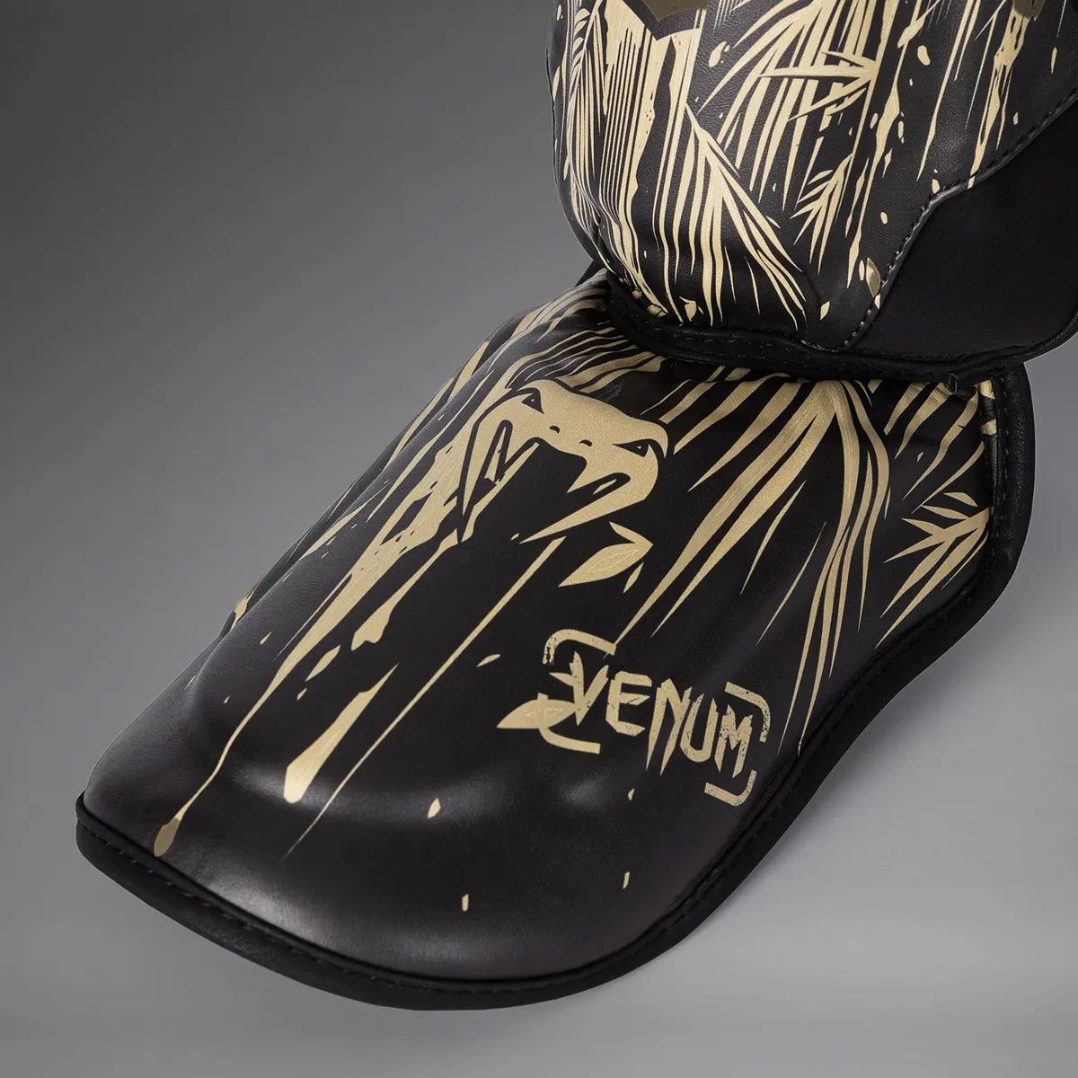 Venum Tiger Shin Guards - Black/Neon Orange детайл от протектора за стъпало с лого